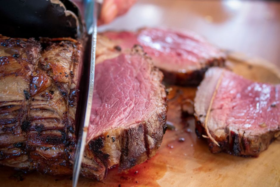 Appetizing close-up of a succulent sliced roast beef with a knife.